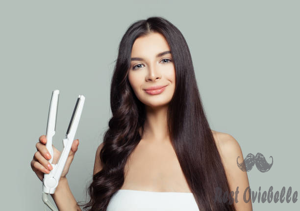 happy woman with straight hair and curly hair using hair straightener. cute girl straightening healthy brunette