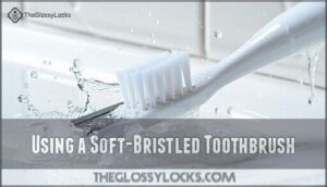 using a soft-bristled toothbrush