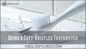using a soft-bristled toothbrush